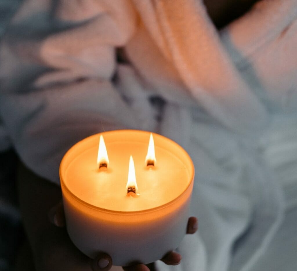 Peitho-Perfumes.ScentedCandles_ A Swiss woman in a bathrobe holding a candle made with molecular perfumes.