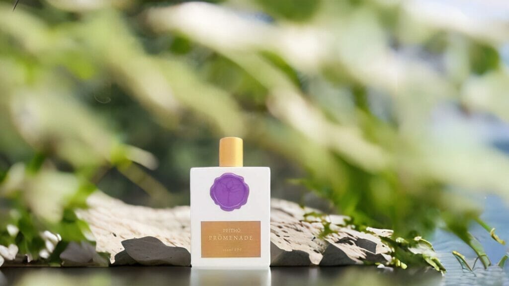 Peitho-Perfumes.ScentedCandles_ A bottle of perfume sitting on a stone next to a lake.