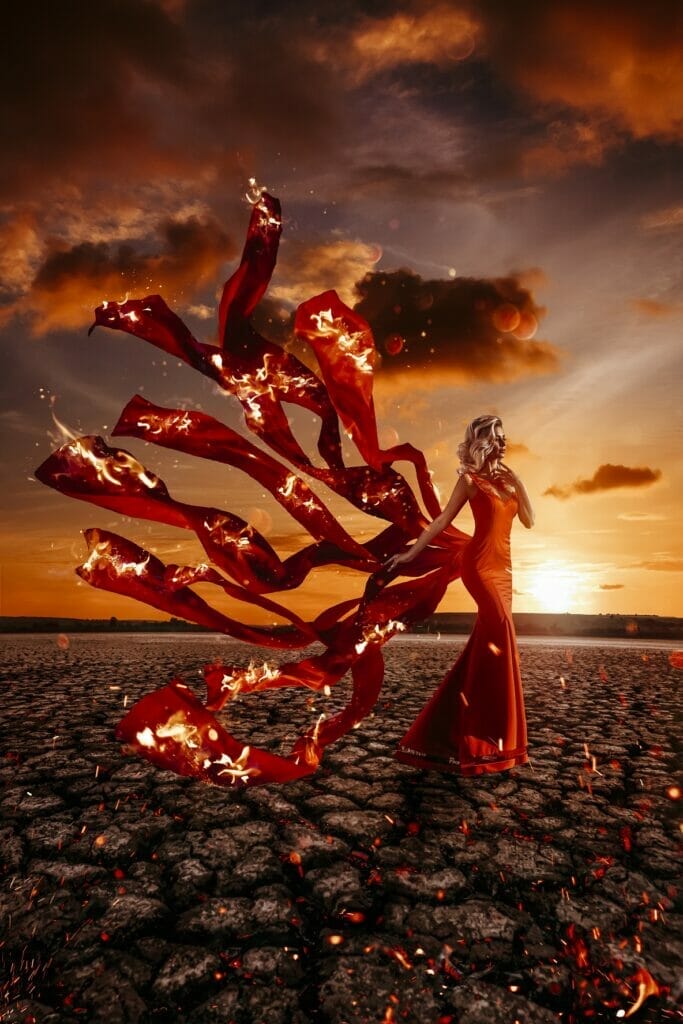 Peitho-Perfumes.ScentedCandles_ A woman in a red dress standing on a deserted field.