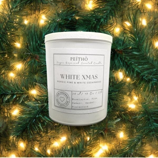 Peitho-Perfumes.ScentedCandles_ A White Xmas - scented candle in front of a Christmas tree.
